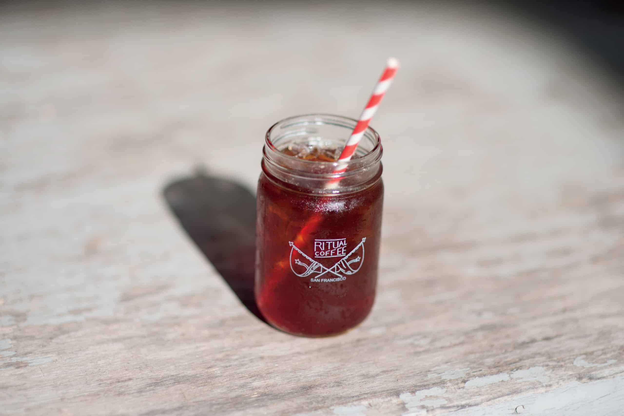 Mason jar of cold brew with a red straw