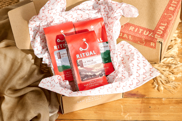 Three 12 ounce bag on top of tissue paper in a cardboard box